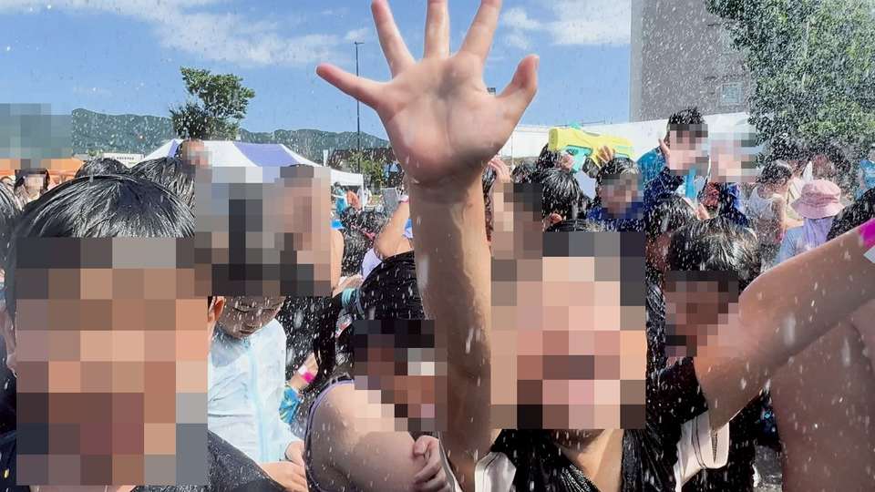 水しぶきの中で手を上げる参加者たち